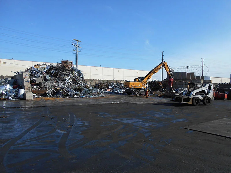 pile of scrap metals and an excavator
